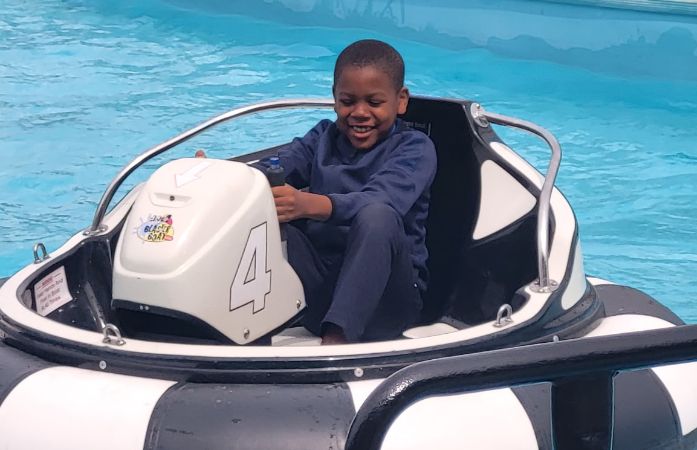  Students seen riding a fun ride at field trip on the water. 